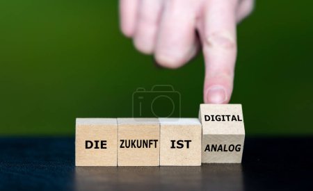 Símbolo para un futuro digital. La mano gira cubos de madera y cambia la expresión alemana 'die Zunkunft ist analog' a 'die Zukunft ist digital' (el futuro es digital).