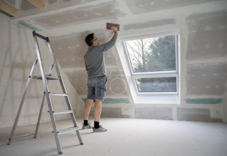 Photo for Man plastering drywall in a private house. - Royalty Free Image