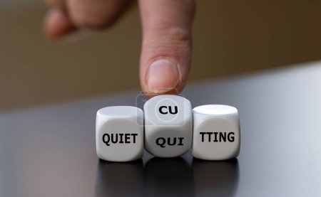 Photo for Hand turns dice and changes the expression 'quiet quitting' to 'quiet cutting'. - Royalty Free Image