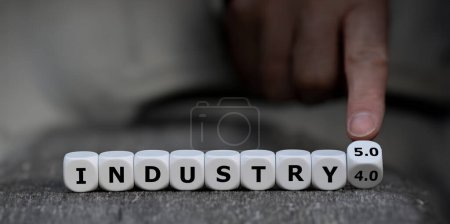 Photo for Hand turns dice and changes the expression 'industry 4.0' to 'industry 5.0'. - Royalty Free Image