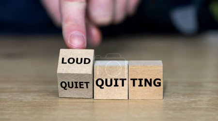 Hand turns wooden cube and changes the expression 'quiet quitting' to 'loud quitting'.