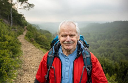 Senior backpacker hiking alone in beautiful landscape. Symbol for staying active at old age. 
