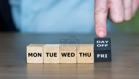 Téléchargez les photos : Symbole pour une semaine de travail de 4 jours. Main tourne cube et change l'expression "FRI" à "jour de congé". - en image libre de droit
