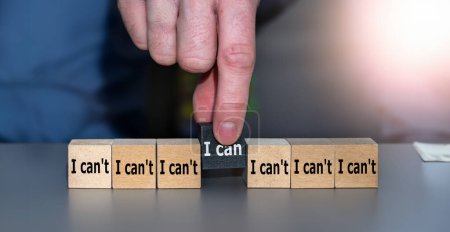 Mano escoge cubo con el texto 'puedo' en lugar de 'no puedo. Símbolo para elegir personas con una actitud positiva en un proceso de reclutamiento.
