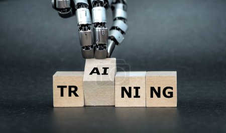 Roboterhand dreht Holzwürfel und setzt die Buchstaben KI (künstliche Intelligenz) auf das Wort Training.