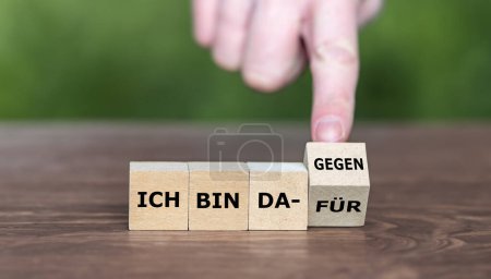 Hand turns cube and changes the German expression ' ich bin dafuer' (I am in favor) to 'ich bin dagegen' (I am against it)