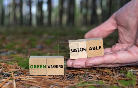 Hand nimmt Würfel mit dem Ausdruck "nachhaltig" anstelle von Würfeln mit dem Ausdruck "grünes Waschen".