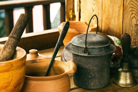 Foto de Primer plano de la artesanía hecha mortero, pestle y otros utensilios de cocina en la mesa de madera en la casa rural. - Imagen libre de derechos