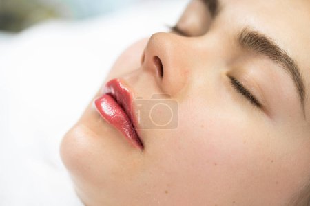 Closeup of female lips after permanent makeup lip blushing procedure