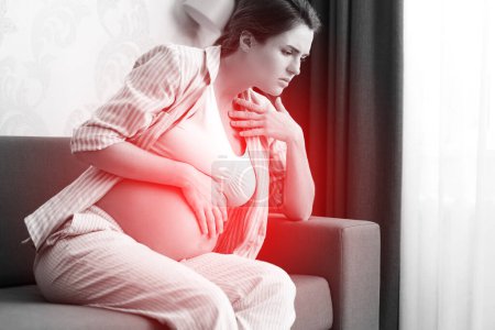Foto de La mujer embarazada en casa se siente enferma. Diferentes problemas de salud durante el embarazo. - Imagen libre de derechos