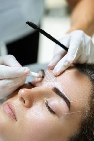 Photo for Young woman during professional eyebrow mapping procedure before permanent makeup - Royalty Free Image