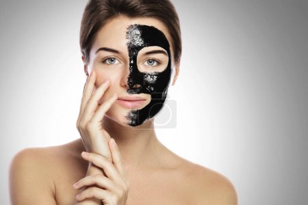 Foto de Mujer joven con máscara negra de limpieza profunda en la cara - Imagen libre de derechos