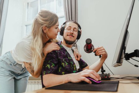 Téléchargez les photos : Jeune gars blogueur et sa belle petite amie au bureau avec ordinateur personnel - en image libre de droit