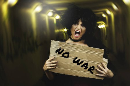 Foto de Retrato de mujer gritando con una pancarta NO GUERRA - Imagen libre de derechos