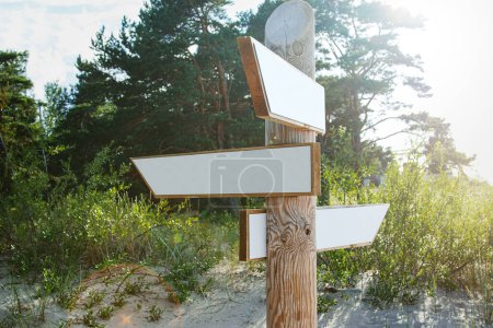 Foto de Primer plano de una señal de madera con flechas en blanco que apuntan en diferentes direcciones. - Imagen libre de derechos