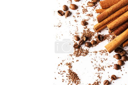 Foto de Tiras de corteza de canela, granos de café y chocolate rallado sobre fondo blanco - Imagen libre de derechos