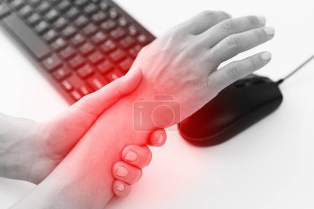 Photo for Young woman working in office with a carpal tunnel syndrome or wrist joint inflammation - Royalty Free Image