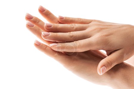 Foto de Primer plano de las manos femeninas con piel suave y hermosa manicura francesa sobre fondo blanco - Imagen libre de derechos