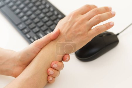 Téléchargez les photos : Gros plan des mains féminines avec une douleur au poignet à cause du syndrome du canal carpien - en image libre de droit