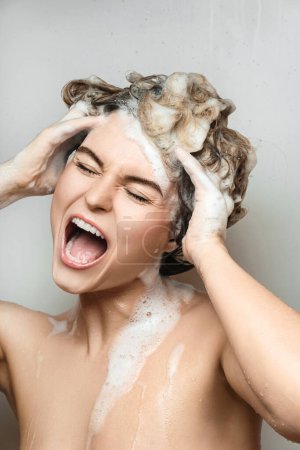 Téléchargez les photos : Portrait de jeune belle femme chantant et se lavant les cheveux avec un shampooing - en image libre de droit