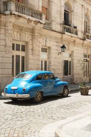 Téléchargez les photos : Vue arrière d'une voiture bleue vintage brillante garée sur la rue. - en image libre de droit