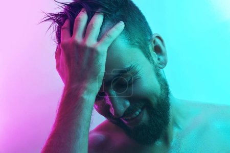 Photo for Portrait of handsome young man with wet skin in neon light - Royalty Free Image