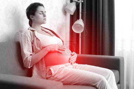 Foto de La mujer embarazada en casa se siente enferma. Diferentes problemas de salud durante el embarazo. - Imagen libre de derechos