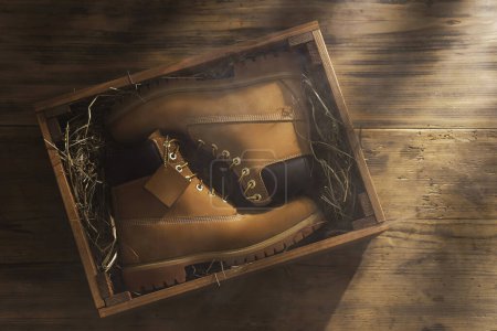 Photo for New leather boots inside the wooden box filled with hay - Royalty Free Image