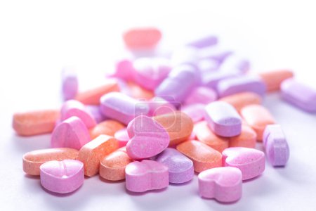Foto de Primer plano de una pila de coloridas píldoras vitamínicas sobre fondo blanco. - Imagen libre de derechos