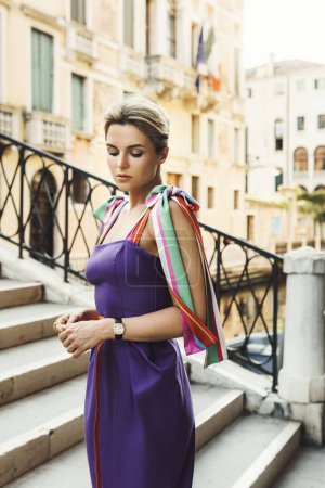 Téléchargez les photos : Portrait de femme magnifique portant une belle robe violette dans la rue de la ville de Venise - en image libre de droit
