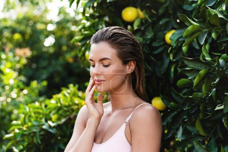 Photo for Outdoor portrait of beautiful woman with smooth skin against lemon trees - Royalty Free Image