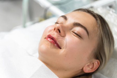 Téléchargez les photos : Femme heureuse après la procédure permanente de rougissement des lèvres de maquillage - en image libre de droit