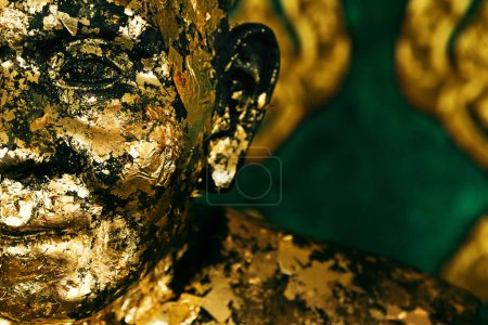 Téléchargez les photos : Gros plan d'une statue de moine bouddhiste en prière minable recouverte de peinture dorée. - en image libre de droit