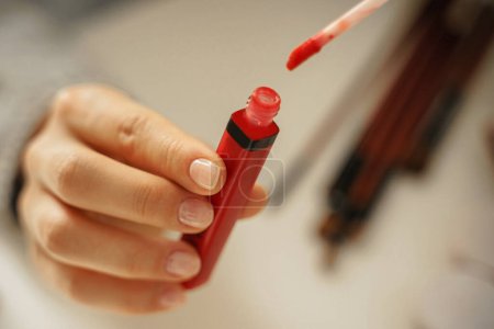 Foto de Primer plano de las manos femeninas con tubo de lápiz labial rojo - Imagen libre de derechos