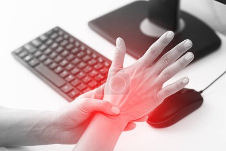 Photo for Young woman working in office with a carpal tunnel syndrome or wrist joint inflammation - Royalty Free Image