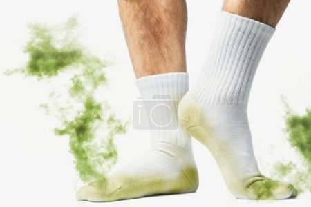 Foto de Pies masculinos con calcetines sucios olorosos sobre fondo blanco - Imagen libre de derechos