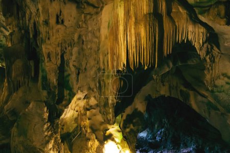 Téléchargez les photos : Grotte souterraine naturelle sombre et effrayante avec des stalactites de pierre étrangement formées. - en image libre de droit