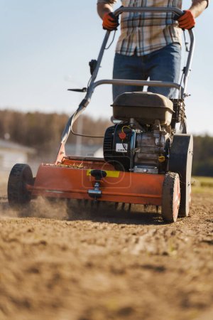 Photo for Closeup shoot of man using aerator machine to scarification and aeration of lawn or meadow - Royalty Free Image