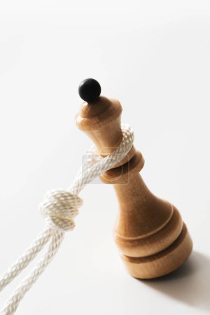 Foto de Primer plano de cuerda blanca tirando de una reina de ajedrez de madera. Concepto de enfrentar dificultades en la vida y ser agobiado por la responsabilidad. - Imagen libre de derechos