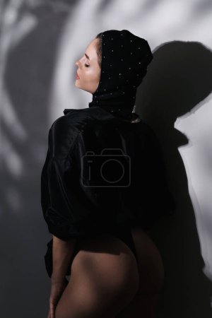 Photo for Fashion portrait of young gorgeous woman wearing rhinestone-embellished balaclava with creative studio light - Royalty Free Image