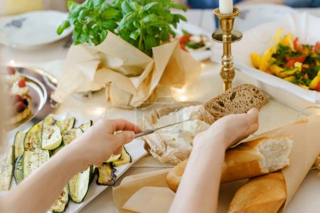 Téléchargez les photos : Gros plan d'une femme préparant un sandwich au fromage à la crème à la table des fêtes. - en image libre de droit