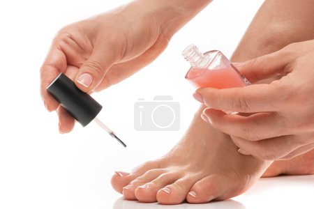 Nahaufnahme des weiblichen Fußes mit schöner französischer Pediküre. Frau trägt rosa Nagellack auf Fußnägel auf.