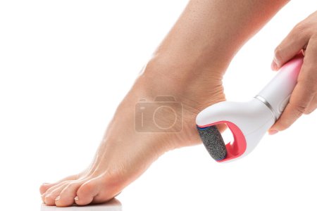 Photo for Closeup of Female feet and electric foot file for callus and dead skin removal on white background - Royalty Free Image
