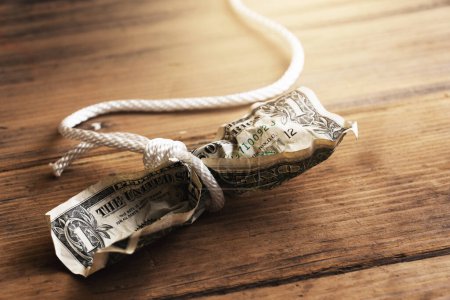 Foto de Cuerda blanca enredada alrededor de un billete de un dólar arrugado. Concepto de fraude monetario, deuda o pagos de crédito. - Imagen libre de derechos