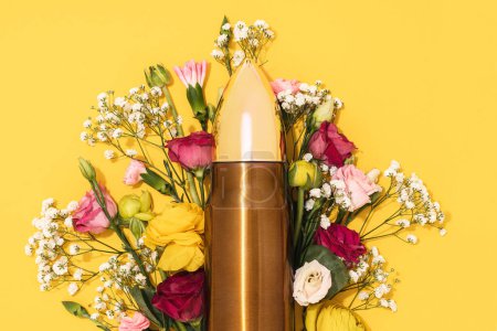 Photo for Pacifism and non-violence movement. Big bullet and bunch of different flowers against yellow background. - Royalty Free Image