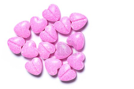 Photo for Closeup shot of a pile of pink heart shaped pills on white background. - Royalty Free Image
