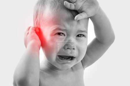 Téléchargez les photos : Gros plan d'un petit bébé pleurant souffrant d'une douleur à l'oreille - en image libre de droit