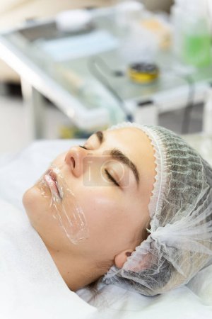 Foto de Artista de maquillaje permanente profesional que aplica anestésico en los labios del cliente antes del procedimiento de rubor labial - Imagen libre de derechos