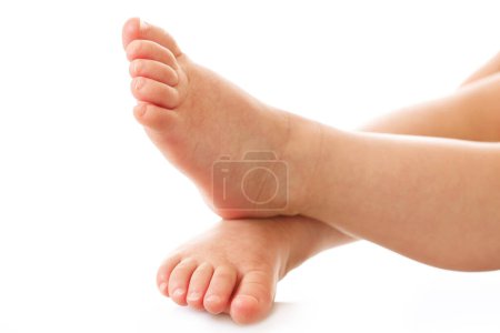 Téléchargez les photos : Gros plan des pieds d'un petit enfant avec une peau lisse et douce sur fond blanc. - en image libre de droit