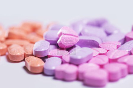 Foto de Primer plano de una pila de coloridas píldoras vitamínicas sobre fondo blanco. - Imagen libre de derechos
